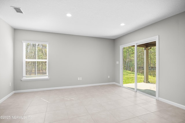 unfurnished room with plenty of natural light, visible vents, and baseboards