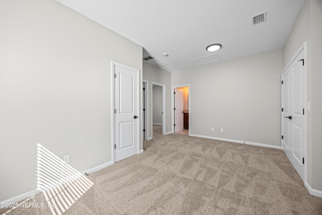 unfurnished bedroom with baseboards, carpet flooring, visible vents, and attic access