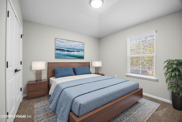 carpeted bedroom featuring vaulted ceiling and baseboards