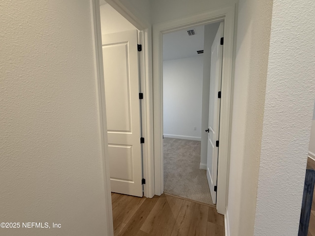 corridor with light hardwood / wood-style floors