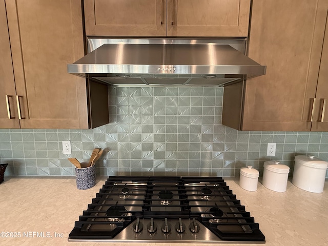 kitchen with stainless steel gas stovetop, tasteful backsplash, and exhaust hood