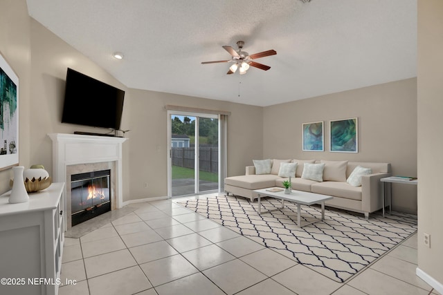 tiled living room with a textured ceiling, a tile fireplace, and ceiling fan