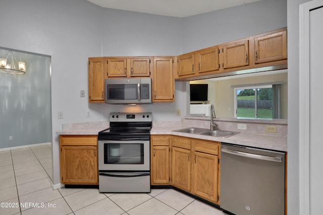 kitchen featuring sink, stainless steel appliances, a chandelier, and light tile patterned flooring