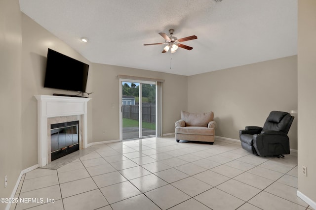 unfurnished room with light tile patterned flooring, a textured ceiling, a fireplace, and ceiling fan