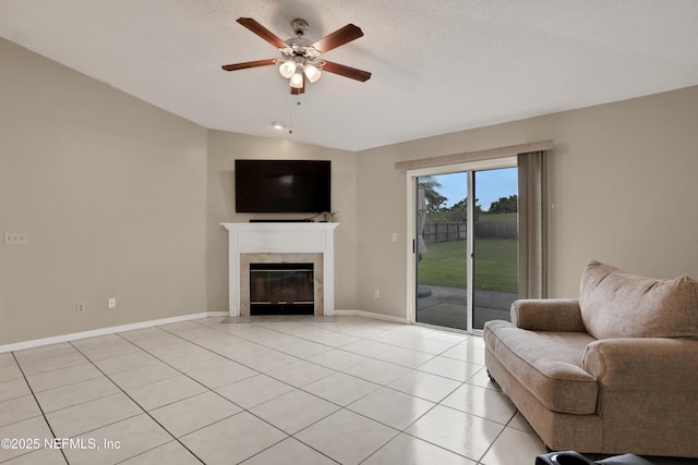 living room featuring vaulted ceiling, a textured ceiling, light tile patterned floors, ceiling fan, and a high end fireplace