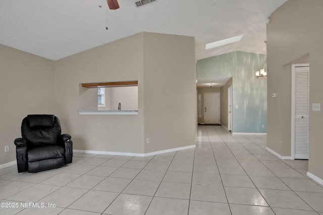 interior space with ceiling fan, lofted ceiling, and light tile patterned floors