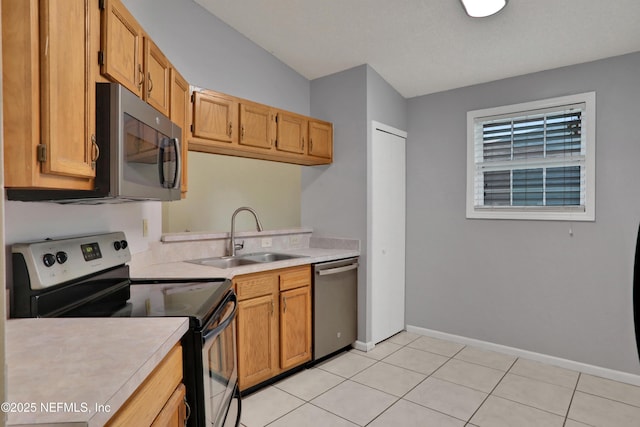 kitchen featuring light tile patterned flooring, appliances with stainless steel finishes, and sink