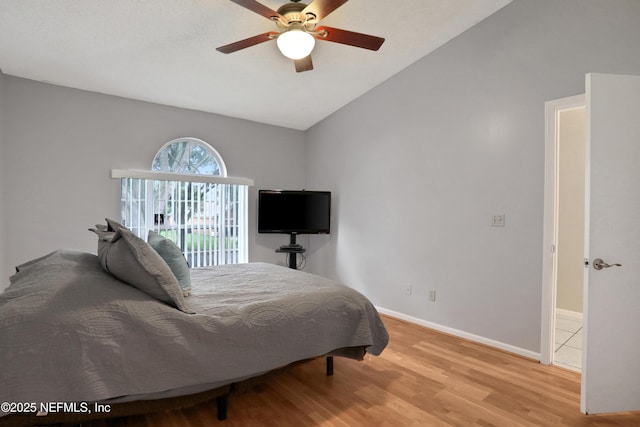 bedroom with ceiling fan, vaulted ceiling, and wood-type flooring