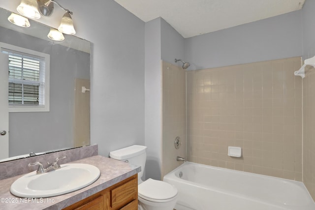 full bathroom with tiled shower / bath combo, vanity, and toilet