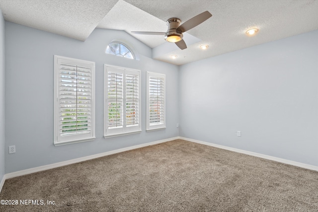 empty room featuring baseboards, carpet, a ceiling fan, and vaulted ceiling