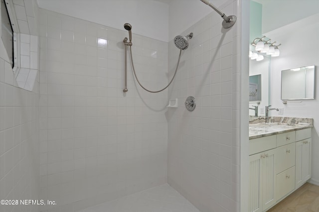 full bath featuring vanity and tiled shower