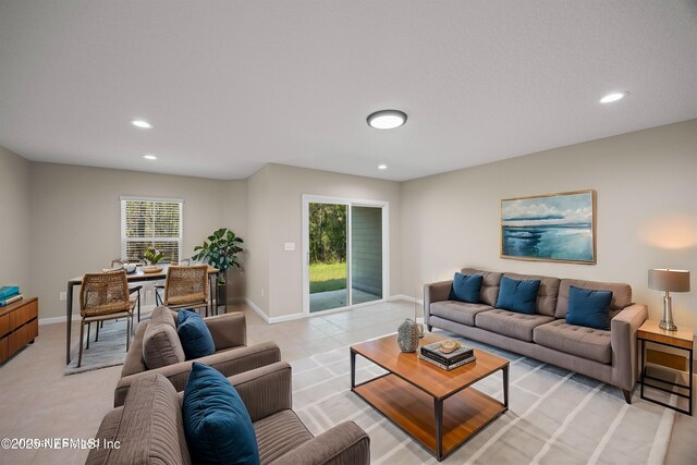 living room featuring baseboards, light tile patterned floors, and recessed lighting