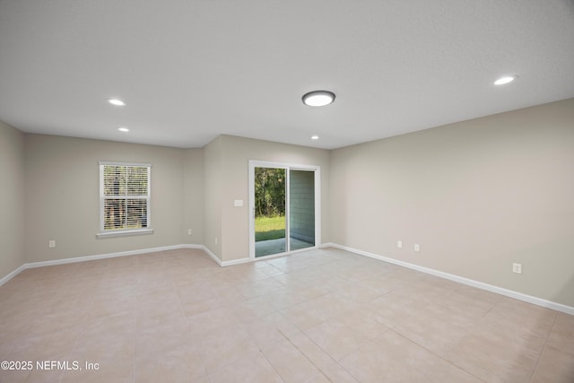 spare room with baseboards and recessed lighting