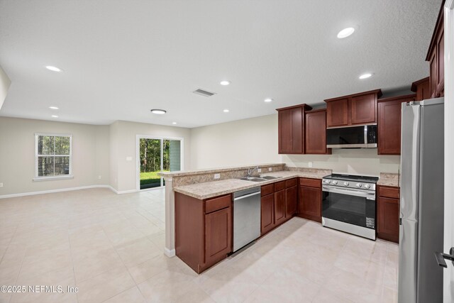 kitchen featuring stainless steel appliances, a peninsula, a sink, visible vents, and open floor plan