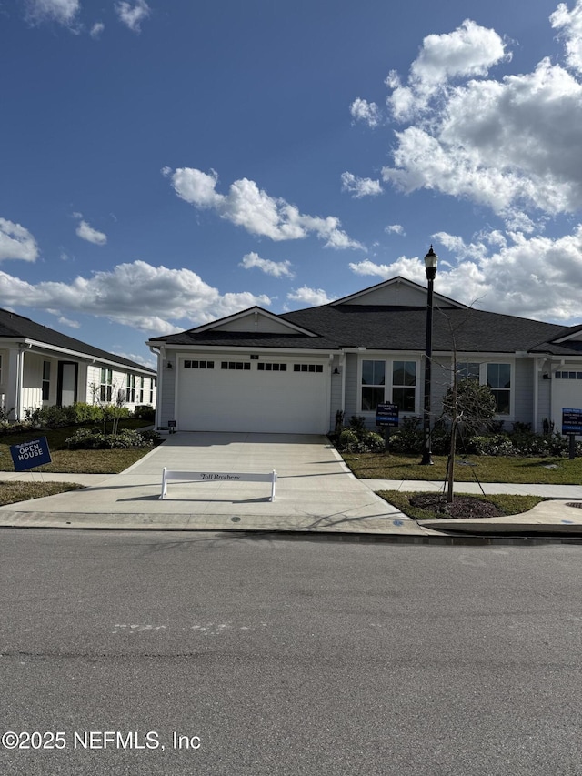 view of front facade with concrete driveway and a garage