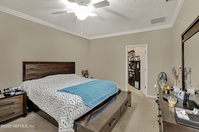 bedroom with ornamental molding, light carpet, ceiling fan, and a textured ceiling