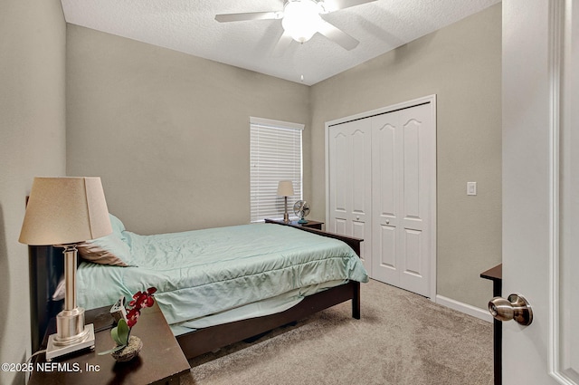 carpeted bedroom featuring ceiling fan, a textured ceiling, and a closet