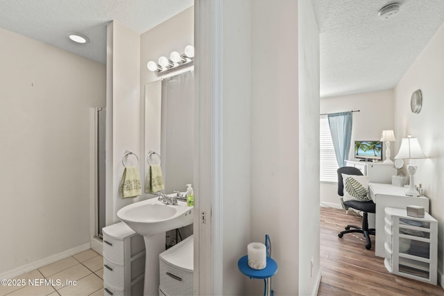 bathroom with sink, a textured ceiling, and hardwood / wood-style floors