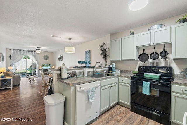 kitchen with sink, dishwasher, kitchen peninsula, hanging light fixtures, and black / electric stove