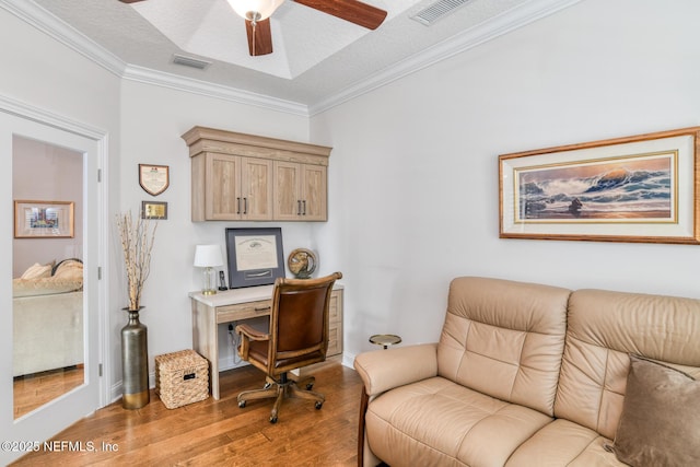 home office featuring light wood-type flooring, crown molding, a textured ceiling, and ceiling fan