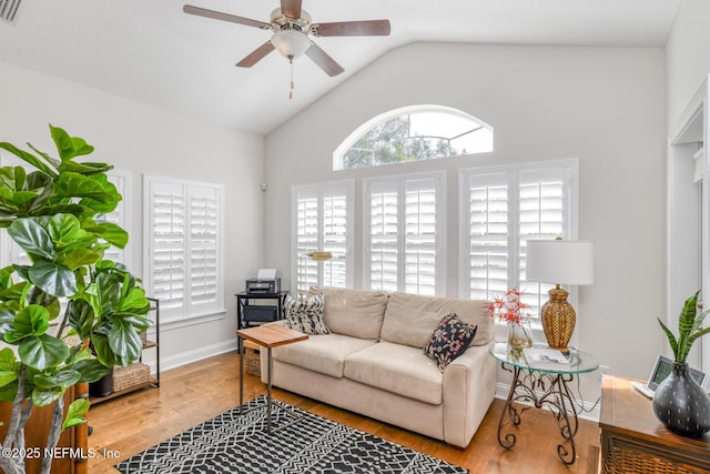 living room featuring ceiling fan, light hardwood / wood-style floors, and vaulted ceiling