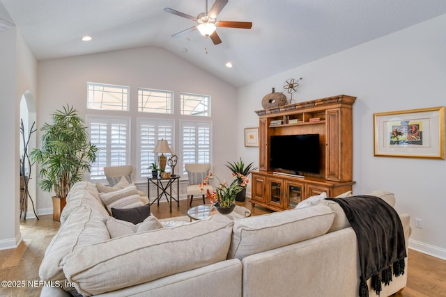 living room with light wood-type flooring, high vaulted ceiling, and ceiling fan