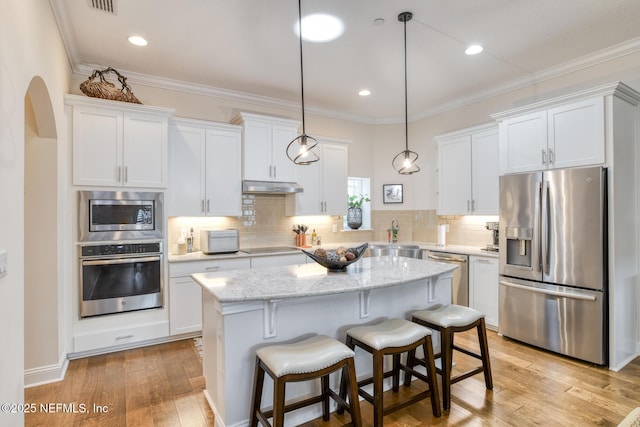 kitchen with stainless steel appliances, decorative light fixtures, light stone countertops, white cabinets, and crown molding