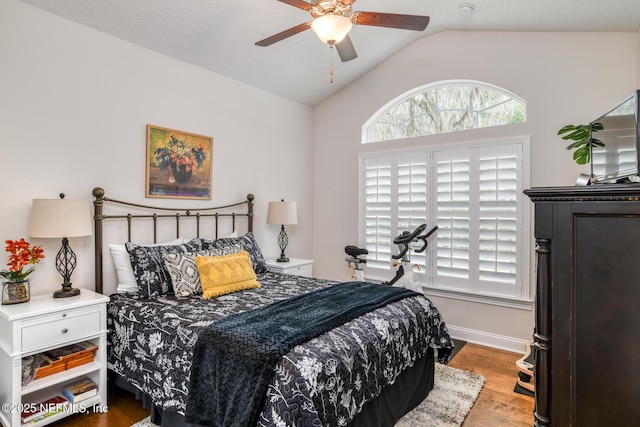 bedroom with ceiling fan, light hardwood / wood-style floors, and lofted ceiling