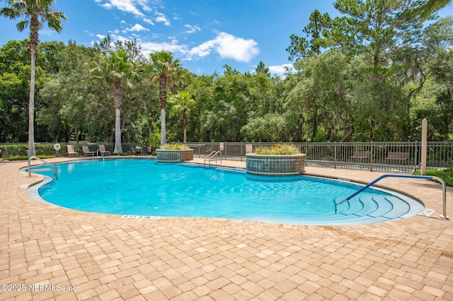 view of pool featuring pool water feature and a patio