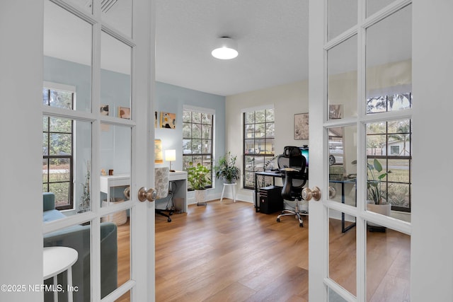 home office featuring a textured ceiling, french doors, and wood finished floors