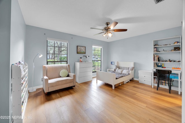 bedroom with wood finished floors, a ceiling fan, and baseboards