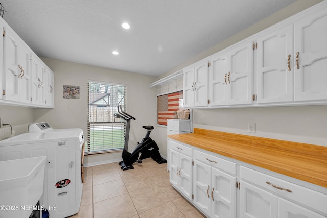 laundry area featuring cabinet space, independent washer and dryer, light tile patterned flooring, a textured ceiling, and recessed lighting