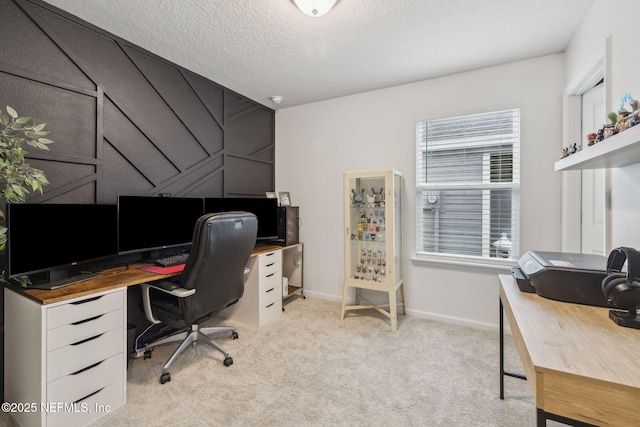 office area featuring light colored carpet, a textured ceiling, and baseboards