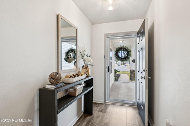 entryway with a textured ceiling and wood finished floors