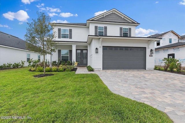 view of front facade featuring a garage, a front lawn, and french doors