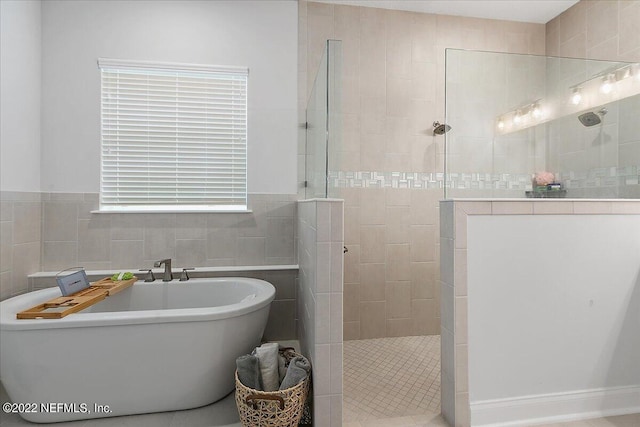 bathroom featuring tile walls and independent shower and bath