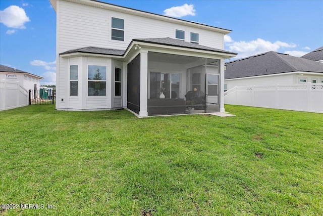 rear view of property featuring a sunroom and a lawn