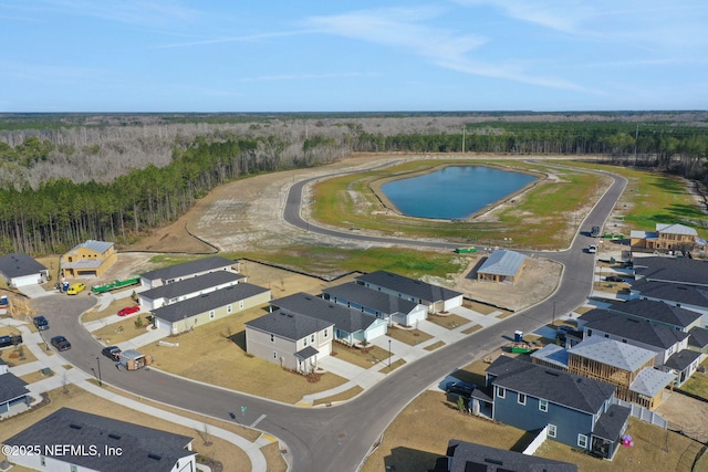 birds eye view of property with a wooded view, a water view, and a residential view