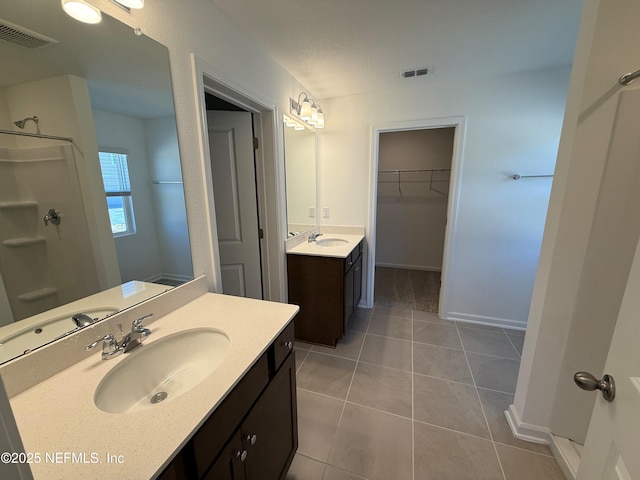 full bathroom with tile patterned floors, visible vents, and a sink
