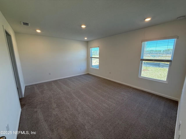 unfurnished room featuring recessed lighting, visible vents, dark carpet, and baseboards