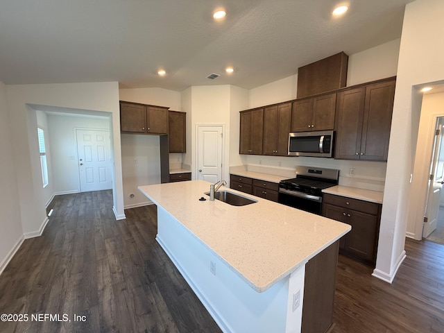 kitchen with dark brown cabinetry, stainless steel appliances, lofted ceiling, and a sink