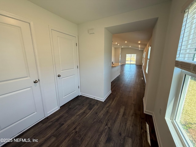 hallway with recessed lighting, baseboards, dark wood-type flooring, and lofted ceiling