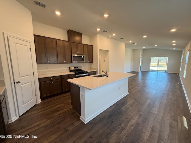 kitchen with visible vents, dark brown cabinetry, dark wood-style floors, stainless steel appliances, and a sink