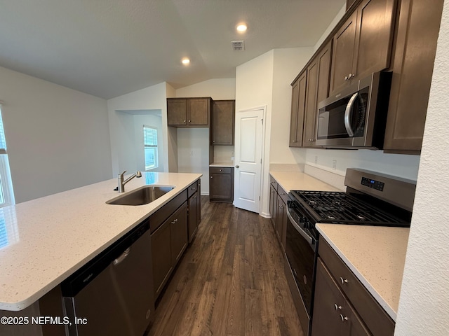 kitchen with visible vents, dark brown cabinets, vaulted ceiling, stainless steel appliances, and a sink