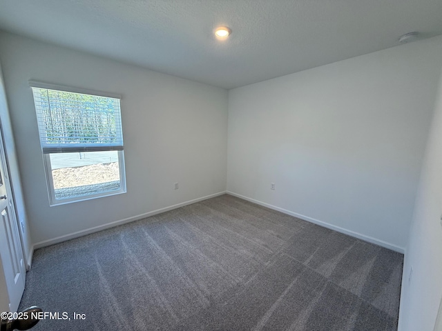 carpeted spare room with baseboards