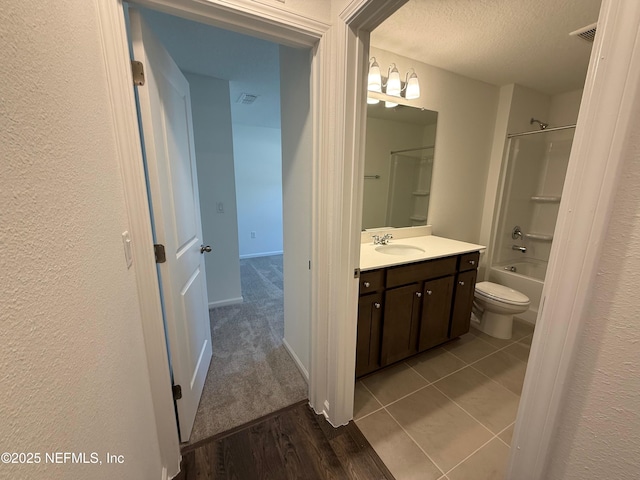 full bathroom with visible vents, a textured ceiling, vanity, and toilet