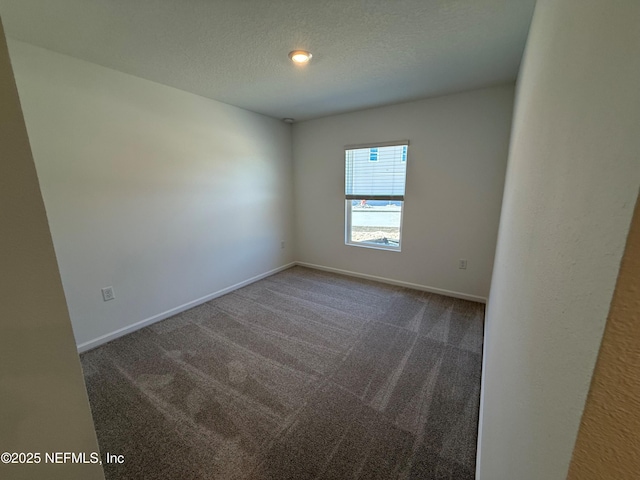 carpeted empty room featuring a textured ceiling and baseboards