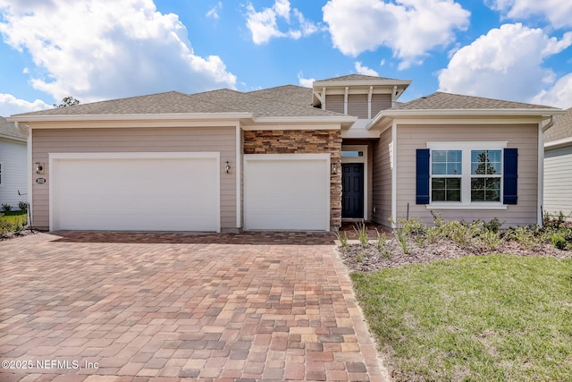 prairie-style house featuring a garage and a front yard