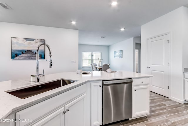 kitchen featuring a sink, visible vents, white cabinets, stainless steel dishwasher, and light stone countertops