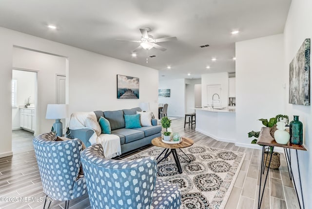 living area with a ceiling fan, recessed lighting, visible vents, and wood tiled floor